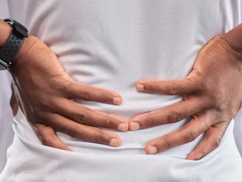 Hands pressed to a lower back in pain