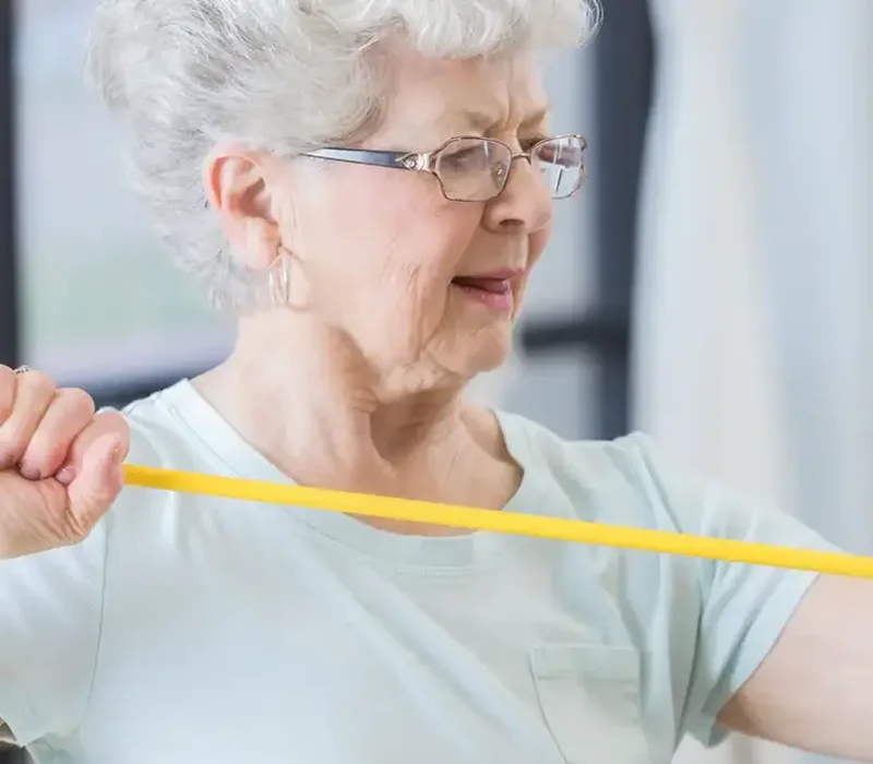 An older woman training with a resistance band