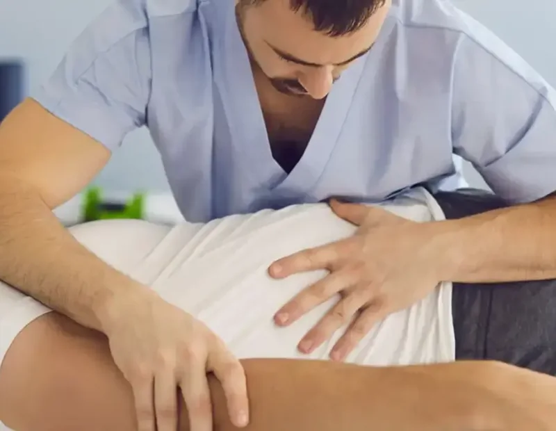A therapist performing hands-on manual therapy on a patient&rsquo;s back