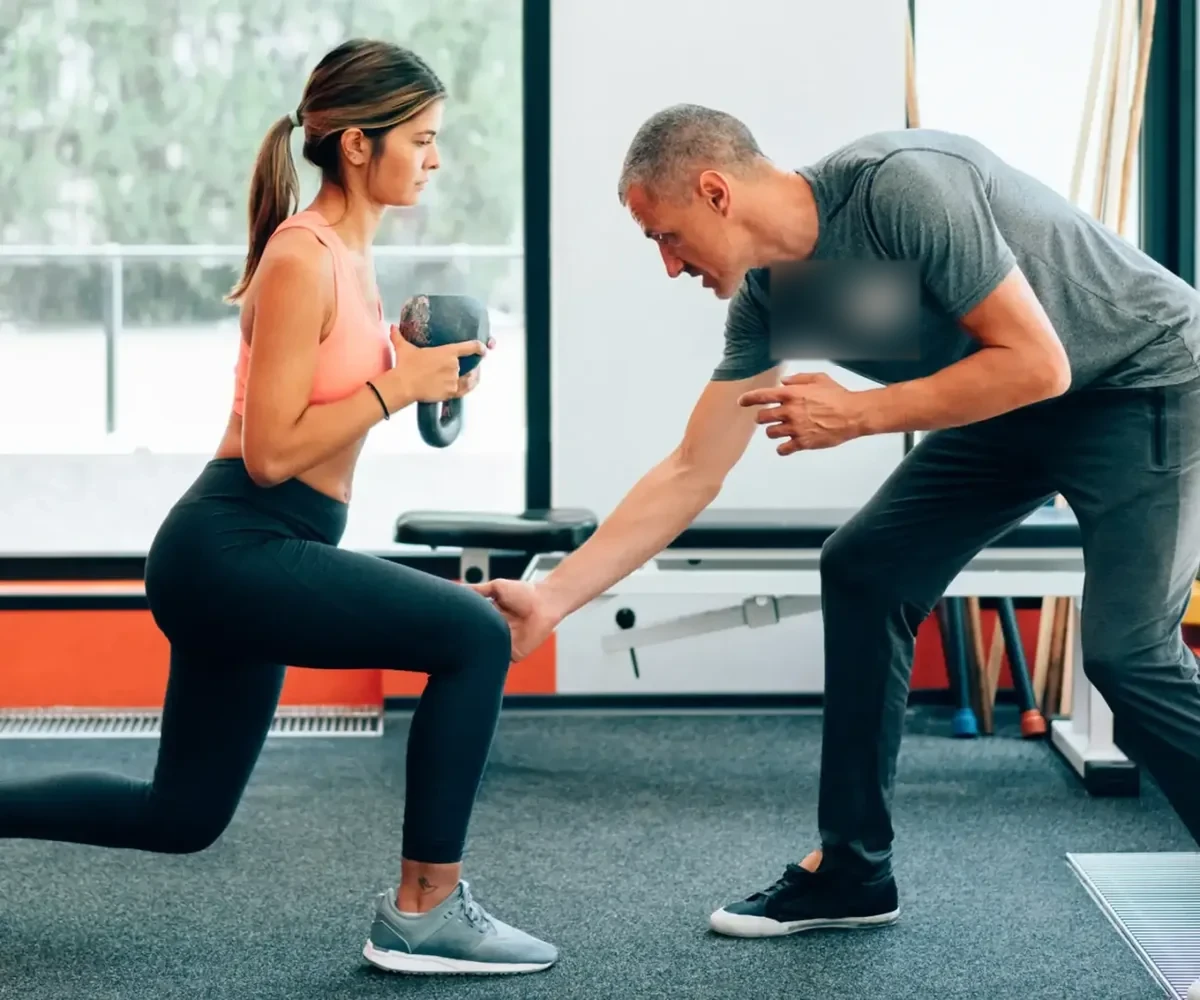 A therapist coaching a patient through a lunge during a physical therapy session